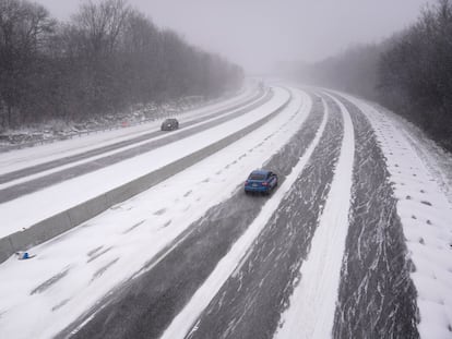 Dos coches avanzan sobre el hielo y la nieve en la interestatal 44, en el Estado de Misuri, este viernes.