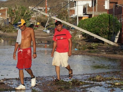 Dos hombres caminan por una calle tras el paso del hurac&aacute;n Patricia en el municipio de Francisco Villa, en el estado mexicano de Jalisco.