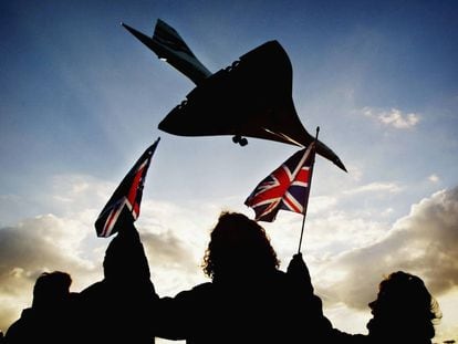 Unos cuantos espectadores agitan banderas británicas en el aeropuerto de Heathrow (Londres) el 24 de octubre de 2003 cuando el Concorde toma tierra en su último vuelo. 
