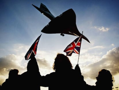 Unos cuantos espectadores agitan banderas británicas en el aeropuerto de Heathrow (Londres) el 24 de octubre de 2003 cuando el Concorde toma tierra en su último vuelo. 