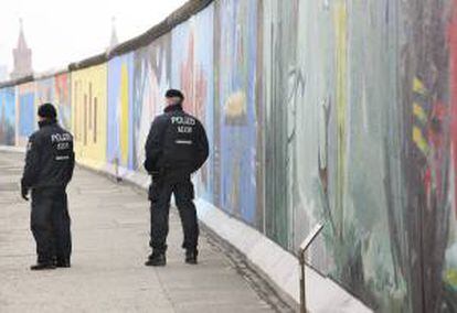 Dos policías vigilan la East Side Gallery, la galería de arte al aire libre perteneciente al Muro de Berlín, Alemania. EFE/Archivo