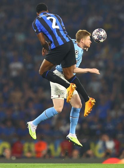 Kevin de Bruyne, del Manchester City, cabecea el balón ante la presencia de Denzel Dumphries del Inter de Milán.