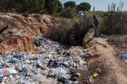 Un joven subsahariano arroja una bolsa de basura en el vertedero de la colonia El Bosque, en Lucena del Puerto. 