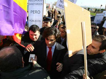 Varios manifestantes rodean a Juan José Güemes a las puertas del hospital de Parla.