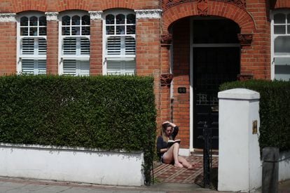 Una mujer lee un libro en un jardín de Londres, el 2 de mayo de 2020. 