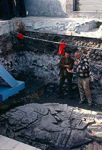 Trabajadores del INAH observan el fragmento de la diosa Coyolxauhqui encontrado en Ciudad de México.
