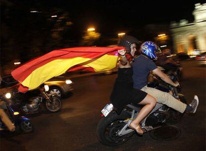 Unos motoristas celebran la victoria de España a su paso por la Puerta de Alcalá