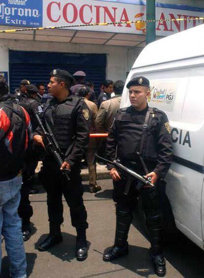 Agentes de la Agencia Federal de Investigaciones Mexicana acordonan el lugar donde ayer fue asesinado en Ciudad de Méxcio un mando policial.
