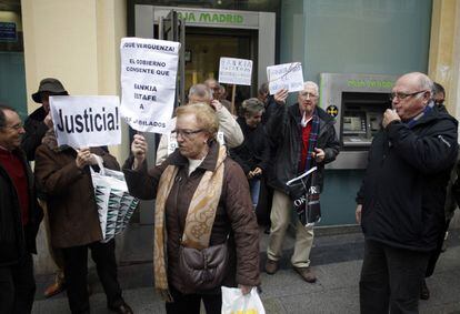 Los encerrados de la sucursal de Bankia salen tras permanecer unas horas ocupando la oficina para protestar por las preferentes.
