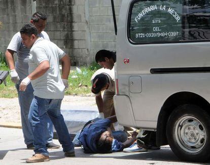 Trabajadores de una funeraria recogen a una víctima en San Pedro Sula.