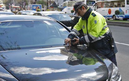 Un polic&iacute;a municipal impone una multa en una calle de Madrid.