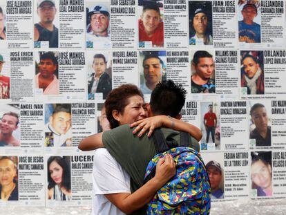 Una mujer abraza a su hijo frente a un mural con información de personas desaparecidas, en Guadalajara (México).