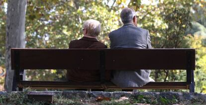 Dos ancianos sentados en un banco de un parque público de Madrid.