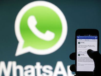 Un usuario de móvil frente al logo de WhatsApp