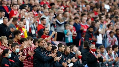 Juergen Klopp y sus asistentes aplauden en la banda durante el homenaje a Michael Robinson en Anfield.