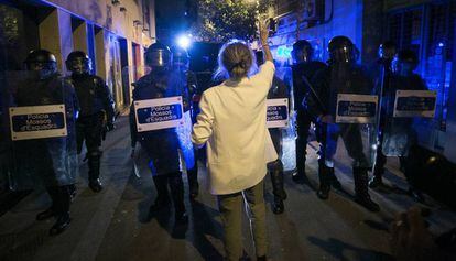 Una mujer protesta junto a un cordón policial.