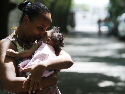 Una mujer en Brasil sujeta a su hija afectada por el virus zika.