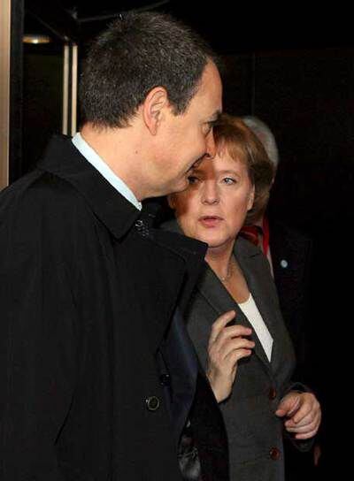 Zapatero y Merkel conversan en la cumbre de Bruselas.