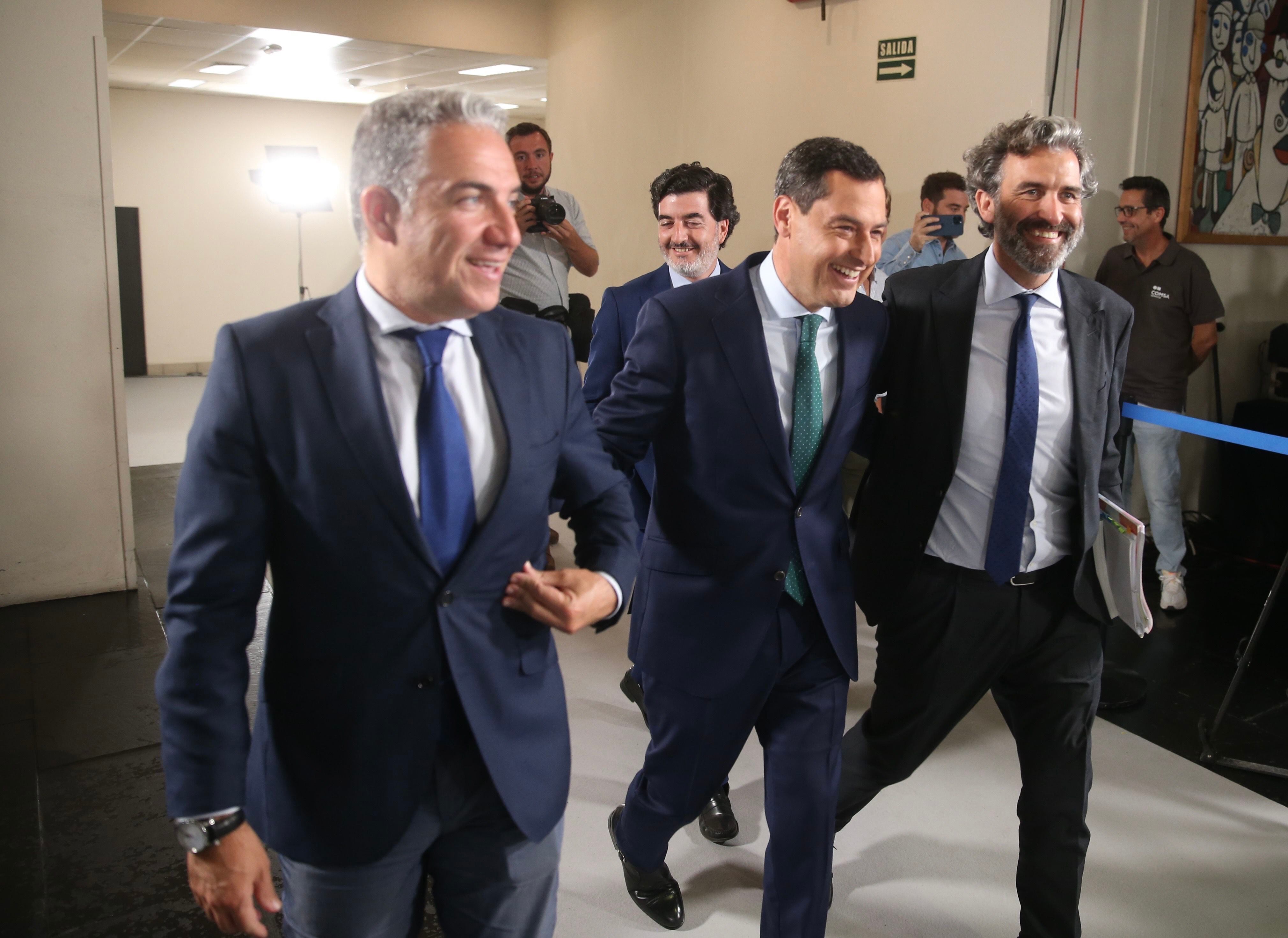 El candidato del PP, Juan Manuel Moreno (en el centro), sale del estudio de RTVE en Sevilla acompañado de su antiguo portavoz y consejero de Presidencia, Elías Bendodo (a la izquierda).