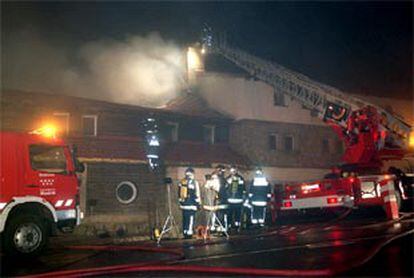 Los bomberos tratan de sofocar el incendio ocurrido en el Club Alpino Español,  situado en el puerto de Navacerrada.