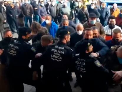 Momento en el que un grupo de personas supera la barrera policial en torno al Ayuntamiento de Lorca (Murcia), este lunes.