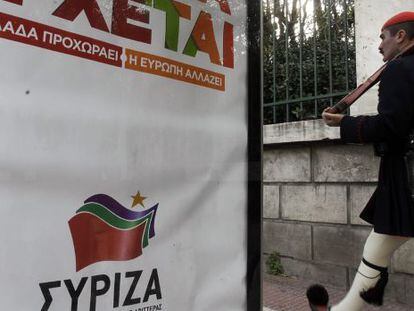 Un guardia presidencial pasa al lado de un cartel del partido griego izquierdista Syriza