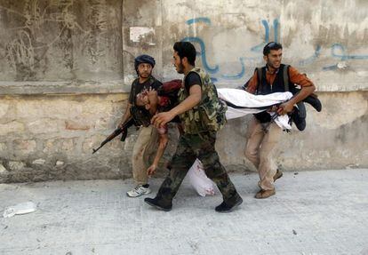 Rebeldes sirios trasladan el cuerpo de un compañero durante los combates en Alepo, en una imagen tomada el 16 de agosto.