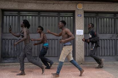 Migrantes corren por las calles de Melilla tras saltar la valla, este viernes.  