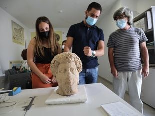 Los concejales Davinia Calderón y Daniel Caballero y el director del museo de Medina Sidonia, Salvador Montañés, inspeccionan una cabeza romana donada por Francisco Guerra.