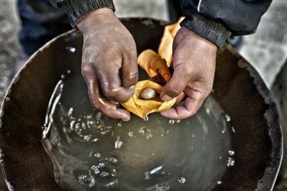 Con un pañuelo se filtra el agua hasta que queda en la mano una pequeña bola de mercurio y oro.