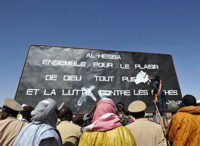 El alcalde de Gao tapa un cartel yihadista donde se lee: “Al Hesba, juntos por el placer de Dios todopoderoso y la lucha contra los pecados”.