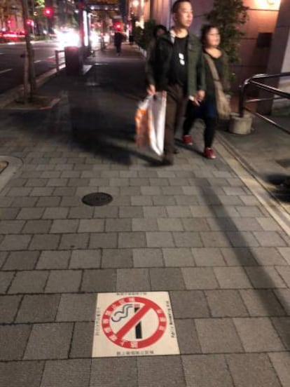 Señal antitabaco en una acera de Japón