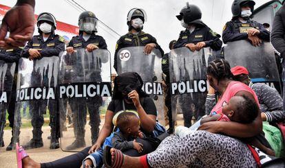 Dos madres migrantes frente al bloqueo de la policía en la localidad peruana de Iñapari, en la frontera con Brasil, este jueves.