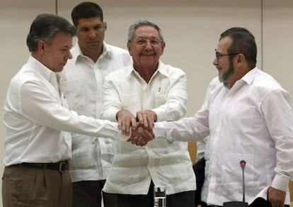 Santos y Timochenko se dan la mano ante Raúl Castro.