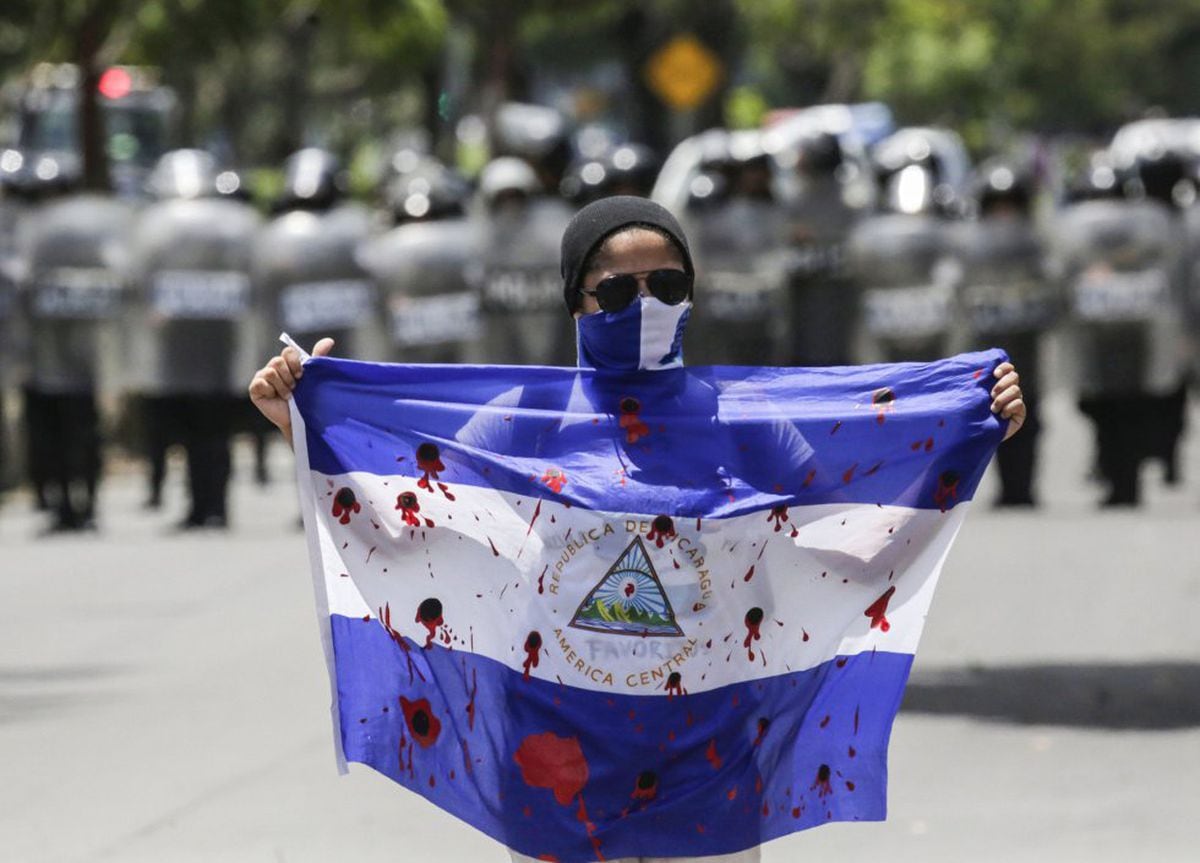 Un manifestante muestra una bandera ensangrentada durante una protesta contra el Gobierno de Daniel Ortega.