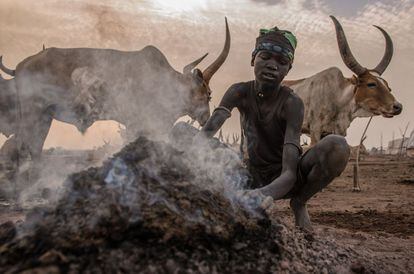 Un niño sudanés de la tribu dinka prepara una hoguera en la madrugada en Mingkaman, en el estado de Lagos (Sudán del Sur).
