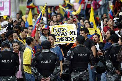 Manifestantes ecuatorianos protestan contra los políticos frente a la sede del Congreso.