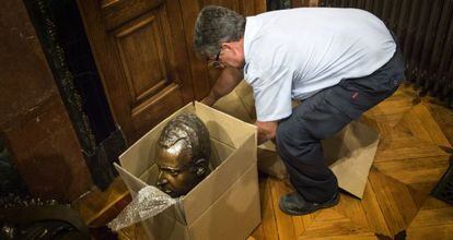 Un operario del Ayuntamiento de Barcelona guarda el busto del Rey.
