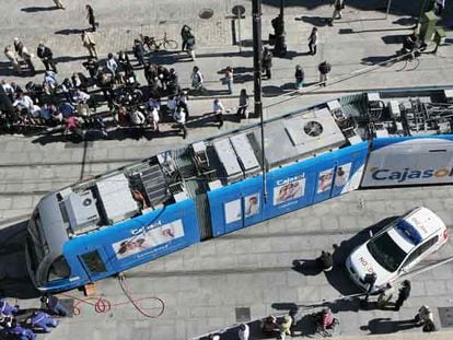 Los operarios del tranvía de Sevilla trabajan para devolverlo a la vía tras descarrilar un vagón.