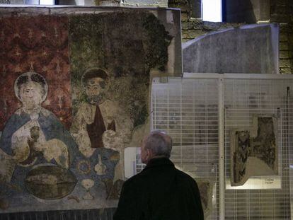 Un visitante observa una de las piezas del tesoro de Sijena instaladas ya en una de las salas del monasterio.