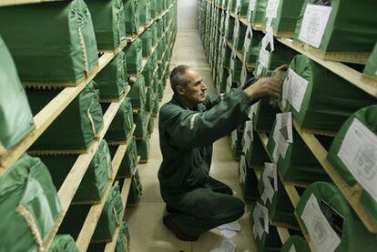 Un empleado coloca los nombres en los ataúdes de las víctimas de Srebrenica halladas en una fosa común tras su identificación ayer.