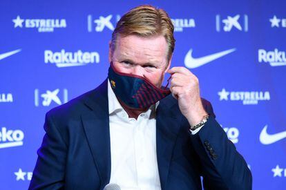 El neerlandés firma un contrato por dos temporadas hasta 2022, la segunda condicionada al nuevo presidente, salido de las elecciones que se celebrarán en 2021. En la foto, el nuevo entrenador del Barcelona, ​​Ronald Koeman, se quita la mascarilla durante su presentación oficial en el Camp Nou.