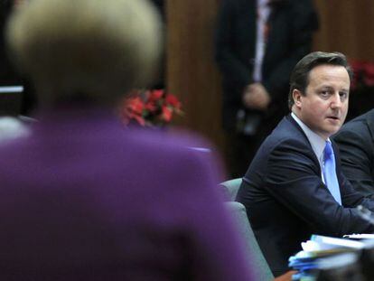 Cameron mira a Merkel (de espaldas) en la cumbre europea.