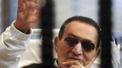 Hosni Mubarak saluda a sus partidarios enjaulado en una sala de audiencias en la academia de policía de El Cairo, en abril de 2013