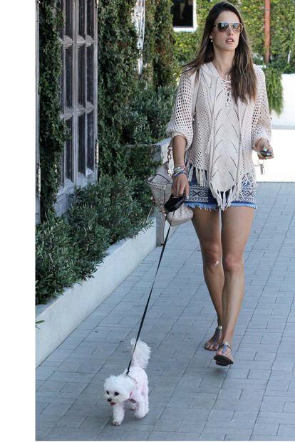 Alessandra Ambrosio, fiel a su estilo hippy, opta por un poncho y short vaqueros para pasear a su perro.