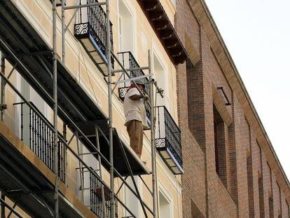 Un hombre trabaja en la rehabilitaci&oacute;n de una fachada en Madrid