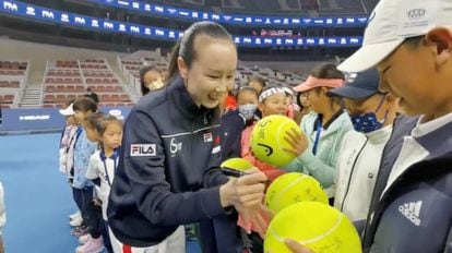La tenista china Peng Shuai firma unas pelotas de tenis en un torneo juvenil en el que reapareció en Pekín el 21 de noviembre.
