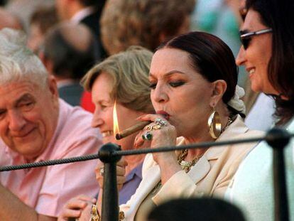 Sara Montiel enciende un puro en una corrida de la Feria de Abril de Sevilla de 1999. 