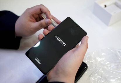 FILE PHOTO: A salesman turns on a new Huawei P30 smartphone for a customer in Beijing