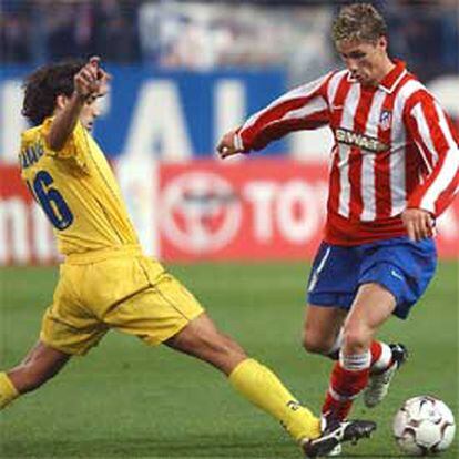 Fernando Torres se lleva un balón en presencia de Quique Álvarez.